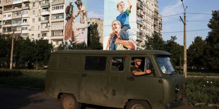 Ukraine servicemen drive past a mural of a family on damaged buildings in Bakhmut, as Russia's invasion of Ukraine continues, in Donetsk region, Ukraine, Aug. 14, 2022 Ukrainian gains prompt Russian military to withdraw from Kharkiv area