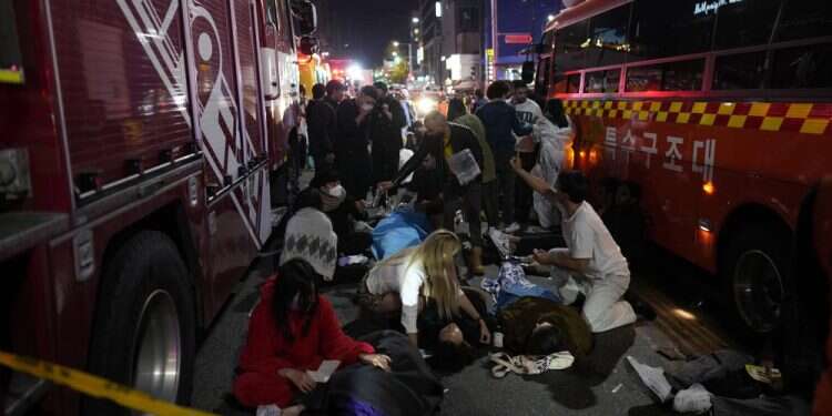 Injured people are helped at the street near the scene in Seoul, South Korea, Oct. 30, 2022 Grief and shock in S. Korea as 151 die in Halloween stampede