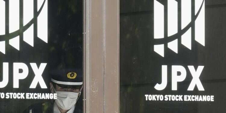 A security guard stands guard at the entrance of the Tokyo Stock Exchange building, Nov. 2, 2022, in Tokyo Global benchmarks mostly rise, markets await Fed rate moves