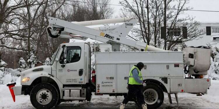 A utility worker walks by a truck in a staging area during a winter storm that hit the Buffalo region in Amherst, New York, US, Dec. 26, 2022 'Once-in-a-lifetime' blizzard kills at least 27 in western NY