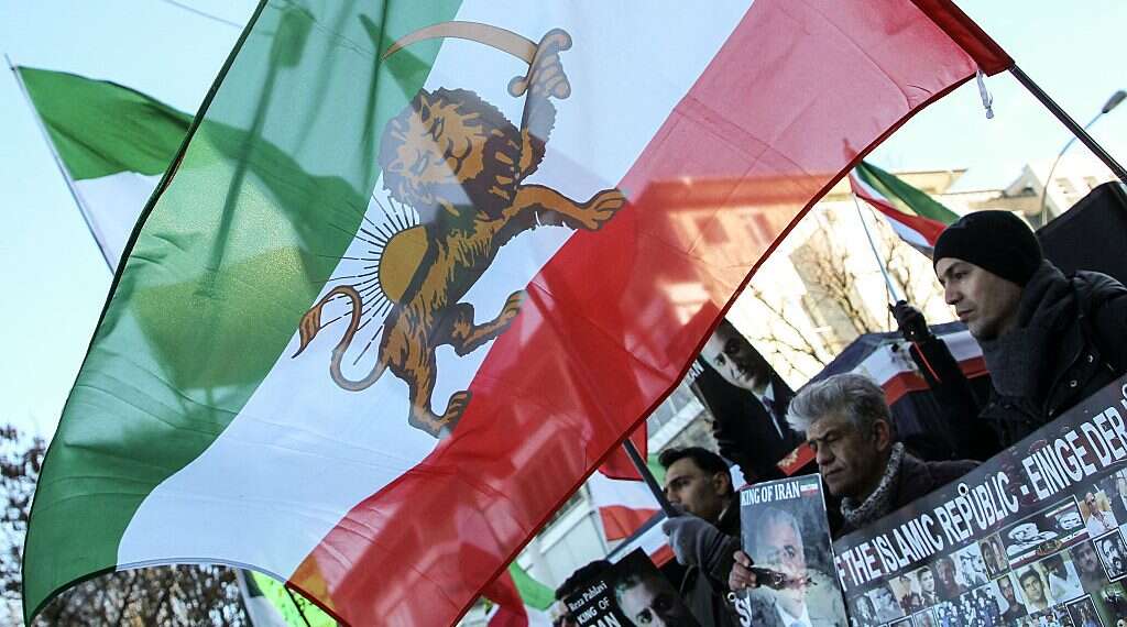 A protester waves the Lion and Sun flag as he takes part in a protest in front of the Iranian consulate in Frankfurt am Main, on December 16, 2022 Report: Anti-regime Iranian cleric makes secret visit to Israel