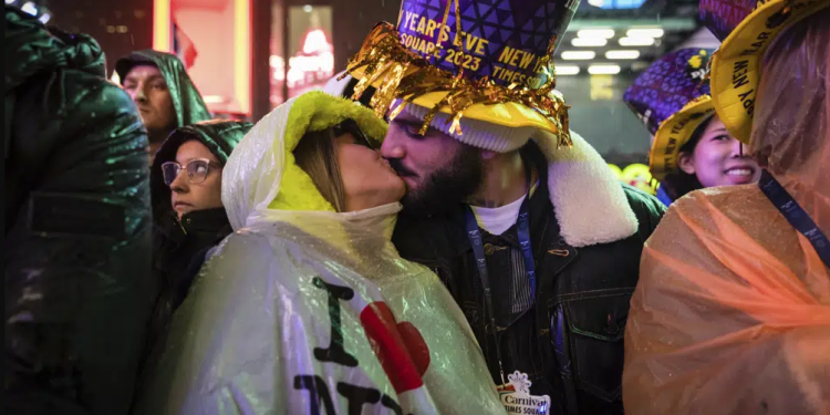 A couple kisses in Times Square as they attend the New Year's Eve celebrations on Saturday, Dec. 31, 2022, in New York Time zone by time zone, 2023 sweeps into view