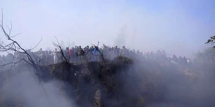 Locals watch the wreckage of a passenger plane in Pokhara, Nepal, Jan.15, 2023