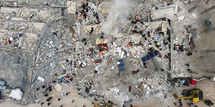 This aerial view shows residents searching for survivors in the rubble of collapsed buildings, following an earthquake on February 6, 2023 Deadly earthquake exacerbates suffering of displaced Syrians