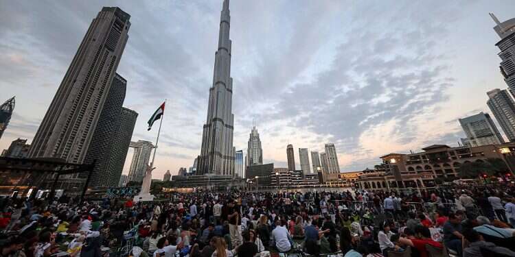People wait near the Burj Khalifa in Dubai, prior to the fireworks of New Year's Eve 2023 Ahead of key UN human rights meeting, report says 'UAE tops countries in region'