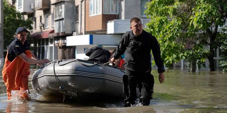 Ukrainian security forces transport a local resident in a boat during an evacuation from a flooded area in Kherson, June 7, 2023, following damages sustained at Kakhovka hydroelectric power plant dam
Ukrainians make desperate escape from floods after dam collapse