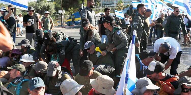 Security officers and anti-government protesters blocking the road leading to the Knesset clash during a protest against the government's planned justice system reform, in Jerusalem, July 24, 2023 Protesters block road leading to Knesset as MKs poised to pass key bill