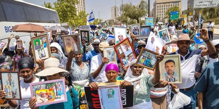 Members of Israel's Ethiopian community protest while holding pictures of their loved ones 'I love Israel and I love my sisters in Ethiopia but it's hard to reconcile the two'