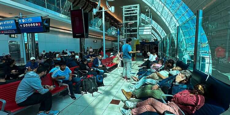 Passengers wait for their flights at the Dubai International Airport in Dubai on April 17, 2024 World's busiest airport suspends flights until Thursday amid severe weather