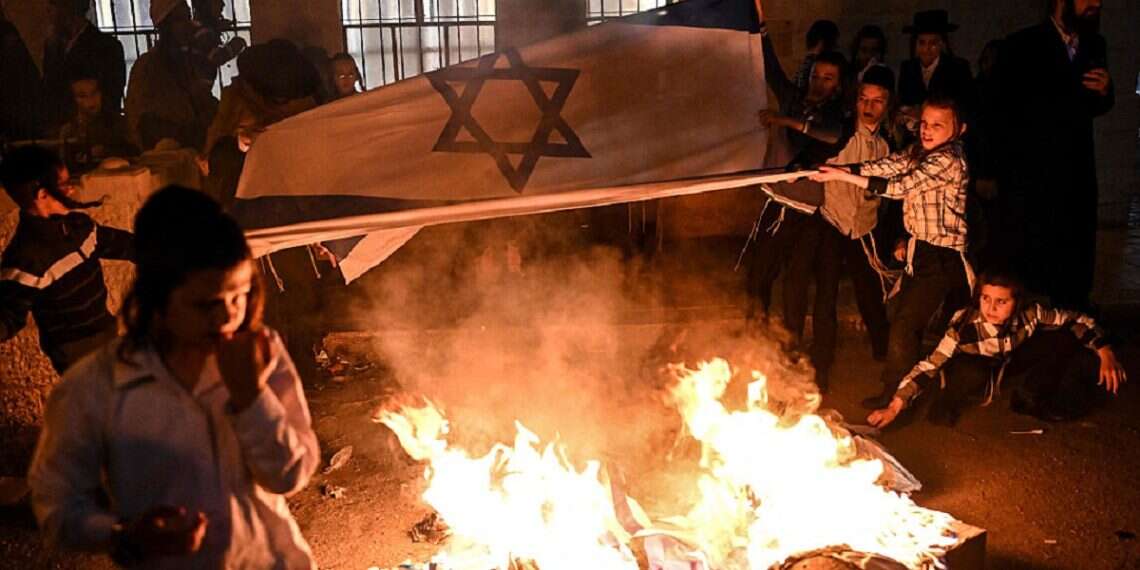 Members of the anti-Zionist Hassidic Jews group, Neturei Karta, burn Israeli flags during a rally against the creation of the state of Israel in Jerusalem's Mea Shearim neighbourhood on May 14, 2024, as the country marks the 76th anniversary of its creation Who are the antizionist Jews aligning with Israel's enemies?