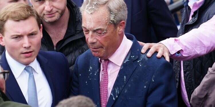 Reform UK party leader Nigel Farage reacts after a woman threw a drink over him, as he launches his election candidacy at Clacton Pier on June 4, 2024 in Clacton-on-Sea, England