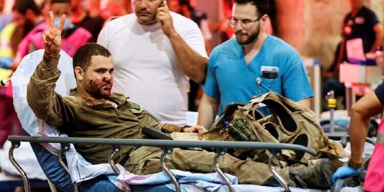 An injured Israeli officer gestures as he arrives at a hospital, following a mass-infiltration by Hamas gunmen from the Gaza Strip, in Ashkelon, southern Israel on October 7, 2023 US doctor fulfills 30-year dream, moves to Israel