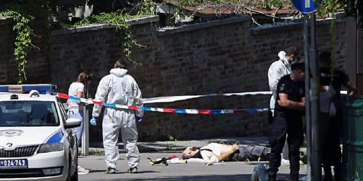 The body of a person lies on the ground, as forensic team members work at the scene, after an attack, near the Israeli embassy in Belgrade, Serbia, on June 29, 2024 Crossbow terror attack at Israeli Embassy in Serbia