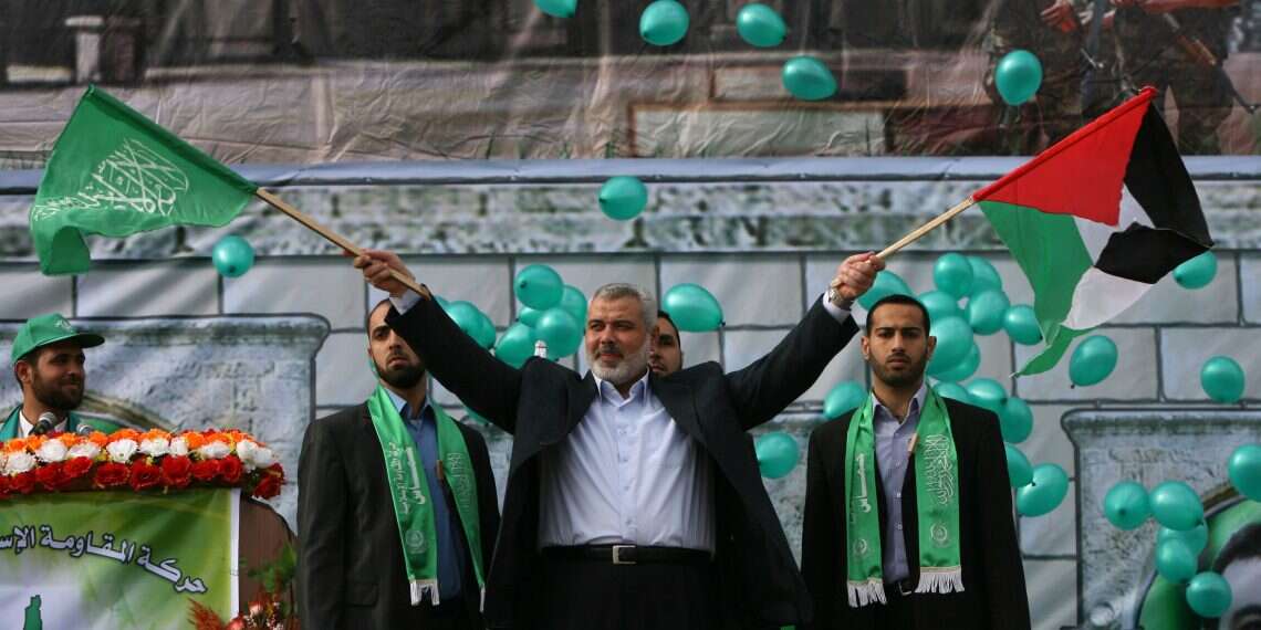 Then-Hamas Prime Minister Ismail Haniya waves the Hamas (L), and the Palestinian (R) flags during a rally in Gaza City on December 14, 2009 marking the 22nd anniversary of the Islamist movement's founding Terrorist mastermind meets his fate'