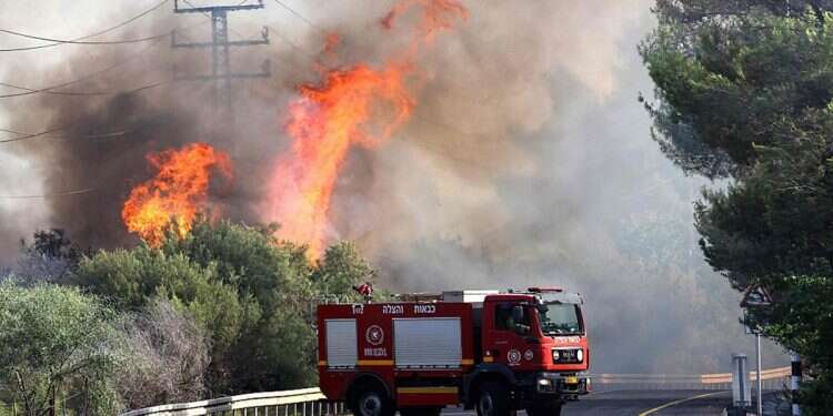 A fire truck arrives at the scene of a fire after rockets fired from southern Lebanon hit an area in the Upper Galilee region in northern Israel on July 4, 2024 Israelis brace for Iran escalation; airspace restrictions imposed