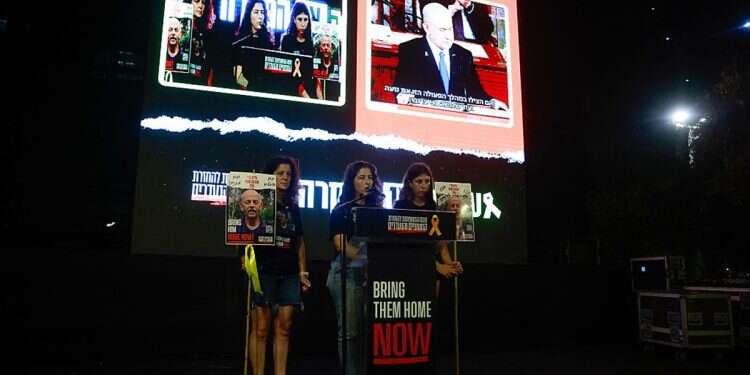 Women carry pictures of late Israeli hostage Chaim Peri as families and supporters of hostages held by the Palestinian militant group Hamas in the Gaza Strip since October 7, gather at the 'hostages square' in Tel Aviv, to watch a live transmission on a large screen of Israeli Prime Minster Benjamin Netanyahu's speech to the US Congress on July 24, 2024 Dead hostage's daughter says PM's priorities 'political'