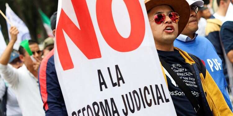 A demonstrator holds a banner reading 'No to the judiciary reform' as he attends a protest against the judicial reform proposed by the Mexican government at the National Autonomous University of Mexico (UNAM) in Mexico City, Mexico August 28, 2024 Mexico proposes masked judges for cartel trials to avoid retaliation