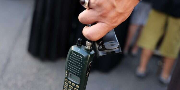 A man holds a walkie talkie device after he removed the battery on September 18, 2024 Schadenfreude, indeed!