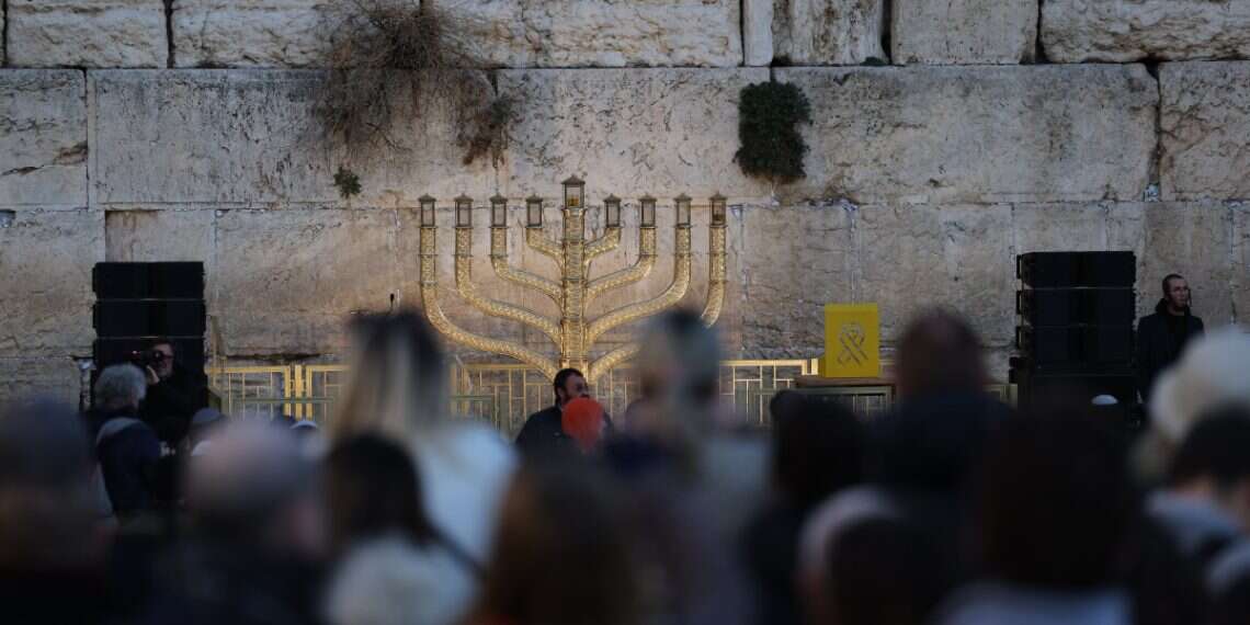 People look at a big menorah during the first Hanukkah candle lighting at the Western Wall in the Old City of Jerusalem, 25 December, 2024 Rabbis mull conversion ban for anti-Israel protesters