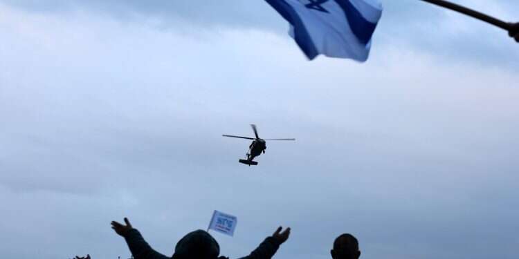People wave the Israeli flag as a military helicopter transporting freed Israeli hostage Omer Wenkert prepares for landing at Beilinson Hospital Rabin Medical Center in Petah Tikva, Israel, 22 February 2025 The goal: Deny Hamas leverage – then resume combat