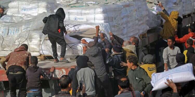 People gather to collect humanitarian aid after trucks arrived in the Gaza Strip via the Kerem Shalom crossing, on January 19, 2025 (Photo: Eyad Baba/AFP) Study finds Hamas starved hostages despite ample Gaza aid