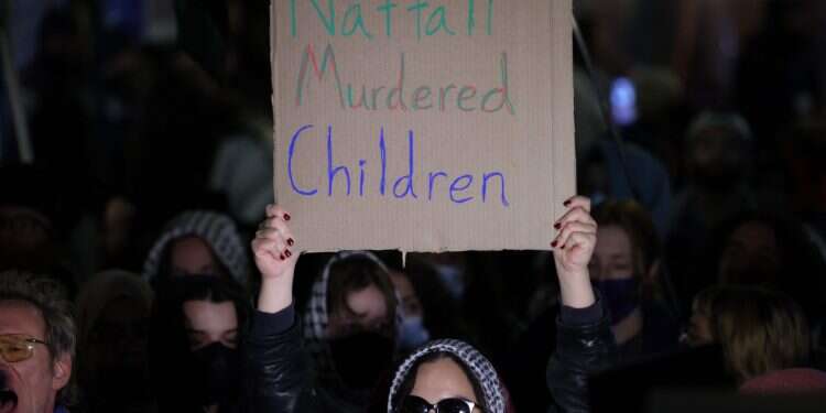 A pro-Palestine protester holds up a sign as they gather outside the campus of Columbia University in New York City on March 4, 2025 Bennett speech at Columbia met with protests