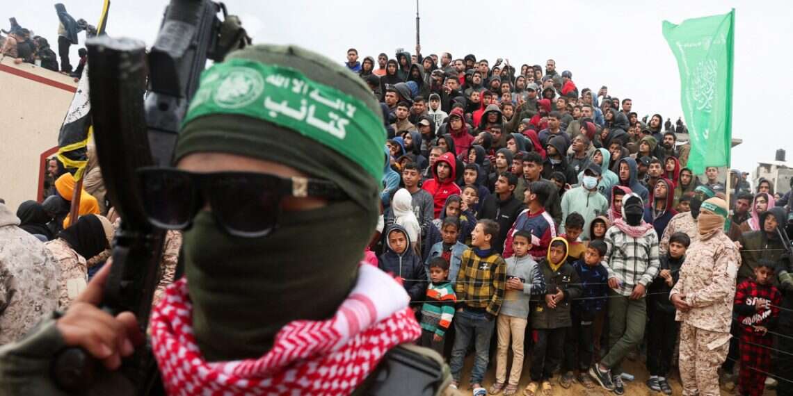 Palestinians look on during the handover by Hamas of deceased hostages Why Israel doesn't trust Hamas' hostage deal proposals