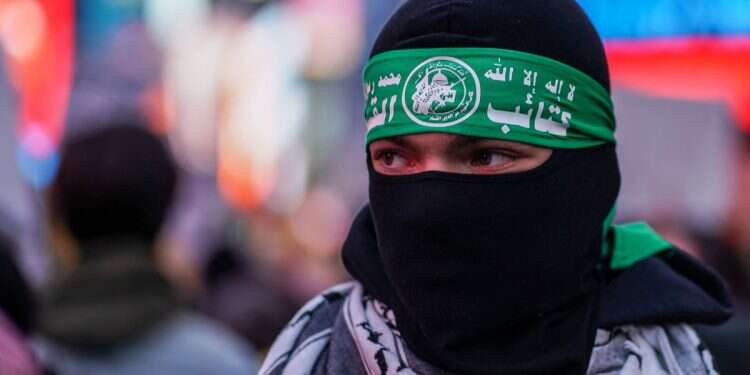 A person wears a Hamas headband during a demonstration at Times Square in New York City, US on March 18, 2025 ( NGO Monitor reveals US dollars flow to terror-associated organizations