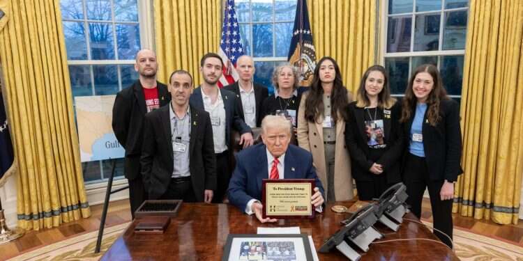 President Donald Trump showing the gift he was given by the released hostages (background) on March 5, 2025 'Release all hostages now or it's over': Trump warns Hamas