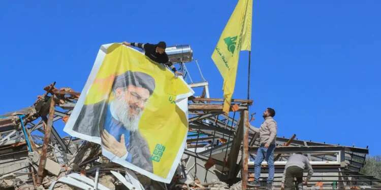 Hezbollah flags against the backdrop of destruction in Lebanon. Photo: AFP Hundreds of Hezbollah commanders flee Lebanon for South America