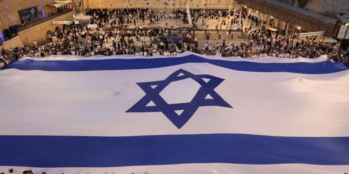 People hold a giant Israeli flag by the Western Wall, Judaism's holiest prayer site, during celebration for Jerusalem Day, in Jerusalem's Old City May 25, 2025 Why Jerusalem? Same reason we didn't choose Uganda