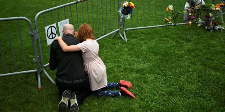 Jon Athan, his daughter Gwen, 9, and son William, 7, embrace at a memorial at the scene of an attack that injured multiple people, outside the Boulder County Courthouse, in Boulder, Colorado, June 2, 2025