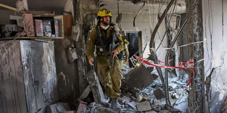 Israeli soldiers from the search and rescue unit work amid the rubble of residential buildings destroyed by an Iranian missile strike that killed several people, in Beersheba, Israel, on Tuesday, June 24, 2025 'Here, under the bed!' Dogs rescued from rubble