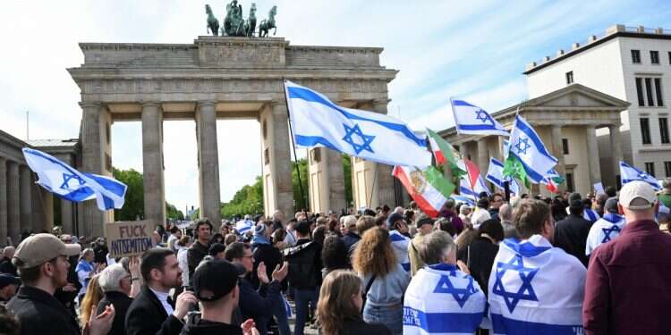 People hold Israeli flags as they gather for a rally in solidarity with Israel, after Iran launched drones and missiles towards Israel, in front of the Brandenburg Gate, in Berlin, Germany, April 14, 2024 Who's with Israel, who's with Iran?