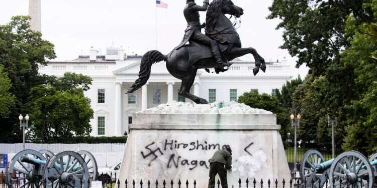 A National Park Service worker paints over an antisemitic graffiti on the base of the Andrew Jackson statue in Lafayette Park, across the street from the White House, in Washington, DC, USA, June 15, 2020 'Hitler was trying to save the world': American podcast sparks outrage