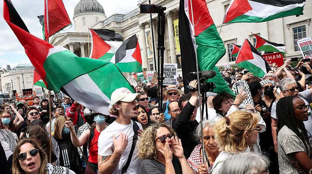 Protestors wave Palestinian flags in front of the National Gallery in Trafalgar Square as the rally for a protest in support of pro-Palestinian group Palestine Action, in central London, on June 23, 2025 There is no concentration camp in Gaza