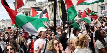 Protestors wave Palestinian flags in front of the National Gallery in Trafalgar Square as the rally for a protest in support of pro-Palestinian group Palestine Action, in central London, on June 23, 2025 There is no concentration camp in Gaza