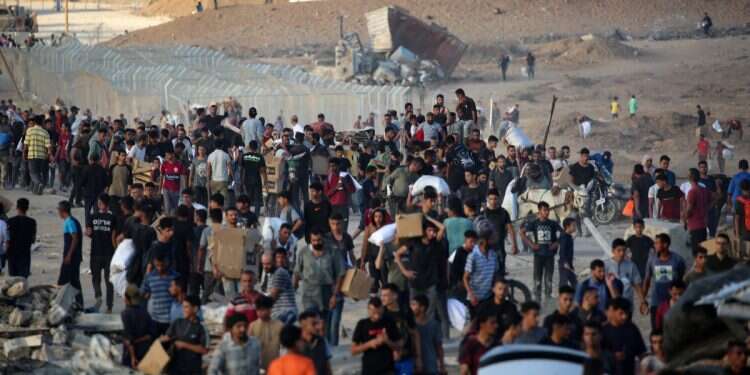 Palestinians gather at an aid distributution point set up by the privately-run Gaza Humanitarian Foundation (GHF), near the Nuseirat refugee camp in the northern Gaza Strip on June 25, 2025 How Hamas, UN are preventing aid from reaching Gazans