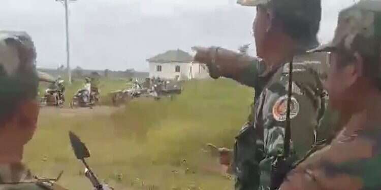 Cambodian soldiers look at people evacuate from along the Cambodia-Thailand border after Cambodian and Thai troops exchanged fire in a new round of clashes in Preah Vihear province on July 24, 2025 Thai fighter jets strike Cambodian targets as countries near war