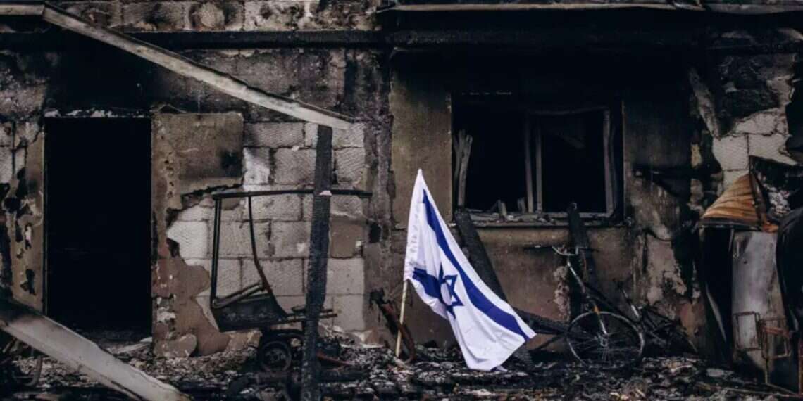 An Israeli flag flies beside a burned house in Kibbutz Be’eri. Photo: Micha Brickman 'The children are choking, the whole kibbutz is burning': The chilling calls to the Fire and Rescue hotline on October 7