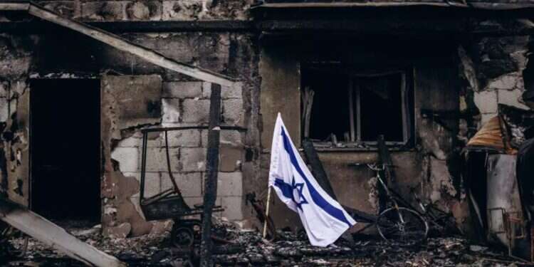 An Israeli flag flies beside a burned house in Kibbutz Be’eri. Photo: Micha Brickman 'The children are choking, the whole kibbutz is burning': The chilling calls to the Fire and Rescue hotline on October 7