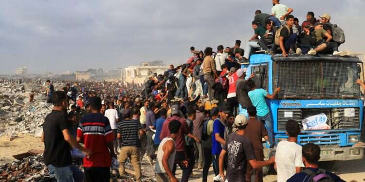 Palestinians climb a vehicle as they gather to receive aid supplies in Beit Lahia, in the northern Gaza Strip, June 23, 2025 PM to 'instruct IDF' how to achieve victory