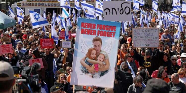 Mourners raise a poster bearing an illustration of Shiri Bibas and her two sons, as people gather to pay their respects at Hostages Square in Tel Aviv on February 26, 2025, on the day of their funeral procession New documentary commemorates Bibas family