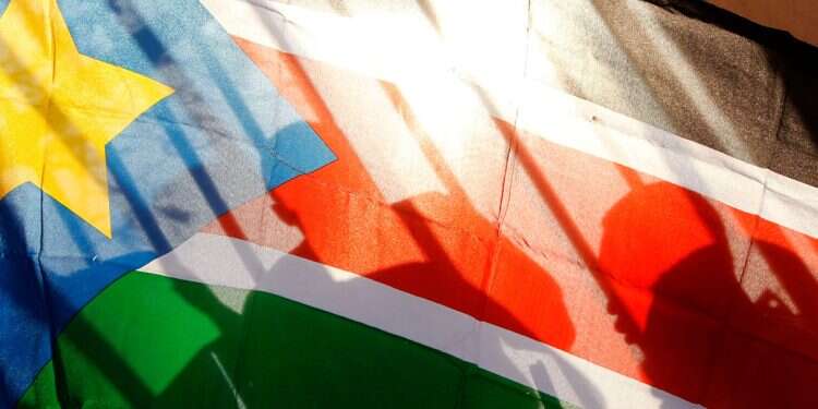 The silhouettes of South Sudanese people are seen through a South Sudanese flag as they line up to cast their votes in Juba, South Sudan, on Jan. 9, 2011 Hunger, civil wars and corruption plague South Sudan as potential destination for Gaza residents