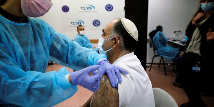 A medical worker administers a vaccination against the coronavirus disease (COVID-19) to a man, at a Maccabi Healthcare Services branch in Ashdod, Israel December 29, 2020 (Photo: Reuters/Amir Cohen) Maccabi's non-kosher sandwich ad angers ultra-Orthodox