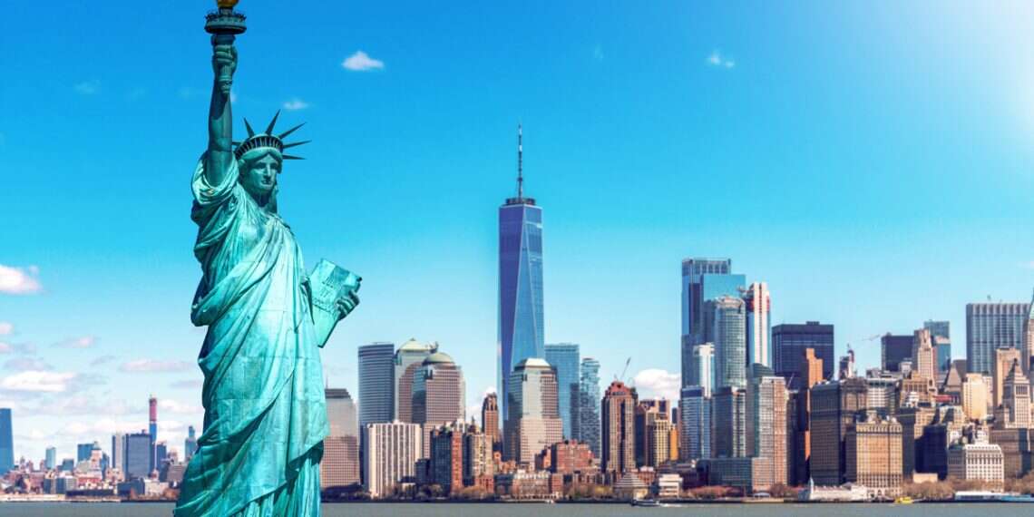 The Statue of Liberty with the One world Trade building center over Hudson river and New York cityscape background, Landmarks of lower Manhattan, New York City Trump's immigration policies trigger unprecedented US tourism decline