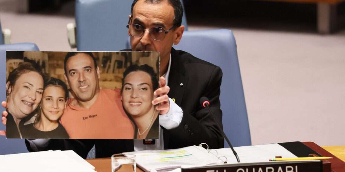 Eli Sharabi, a former hostage, holds up a picture of his family as he speaks during a United Nations Security Council meeting at the United Nations headquarters on March 20, 2025 in New York City 'Hostage': Eli Sharabi becomes NYT bestseller