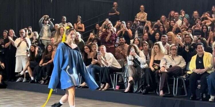 Wearing a yellow ribbon and oversized denim dress, former hostage Maya Regev walked the runway Wednesday during the Upcoming Designers fashion show at Israel Canada Tel Aviv Fashion Week 2025 Hostage survivor Maya Regev walks Tel Aviv Fashion Week runway