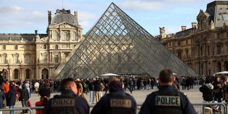 Police officers stand guard near the Louvre Pyramid, after French police arrested suspects in the Louvre heist case, at the Louvre Museum in Paris, France, October 26, 2025 Israeli intel firm blames French ego for sabotaging Louvre theft recovery