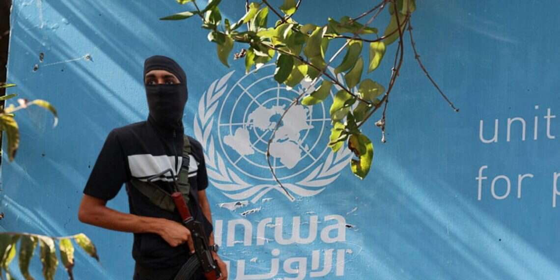 A Hamas terrorists against the backdrop of an UNRWA building (reproduction) US pivots on Gaza's 'day after' plan; UNRWA avoids sanctions